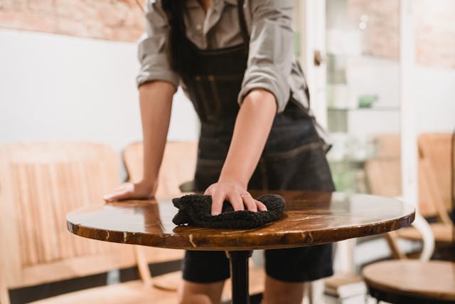 Staff wiping down a restaurant table between services